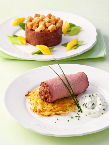 Filled, rolled roast beef sliced and a timbale of steak tartare with croutons