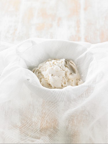 How to prepare vegan macadamia nut cheese: the drained cheese mixture in a muslin cloth