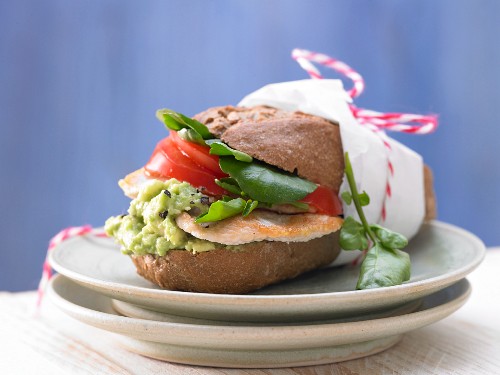 A turkey sandwich with avocado cream, watercress and tomato