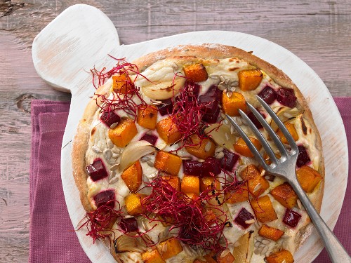 A pizza with beetroot and pumpkin