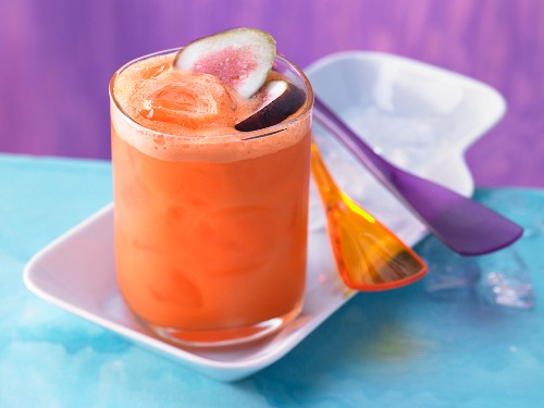A carrot and mandarin drink with lime juice and figs