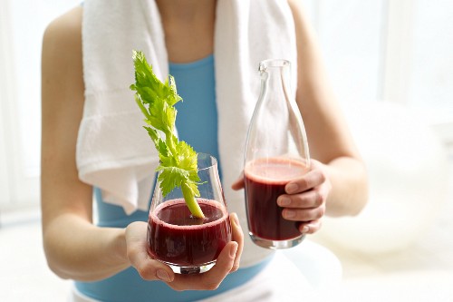 Pomegranate juice with ginger and lemon, garnished with celery