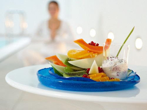 Fruit plate with papaya, kiwi, orange, pomegranate and grapefruit yoghurt