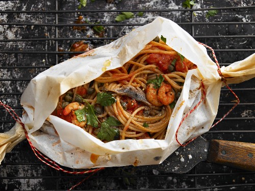 Spaghetti in parchment with shrimp and tomato sauce