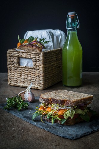 Vegan sandwiches for picnic with roasted carrots, pea spread, and green leafs
