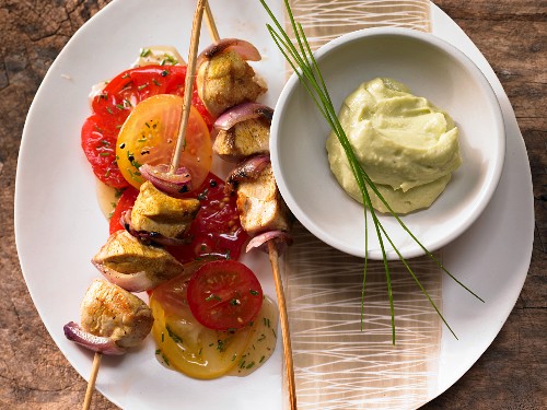 Chicken skewers and tomato salad with avocado and yoghurt cream