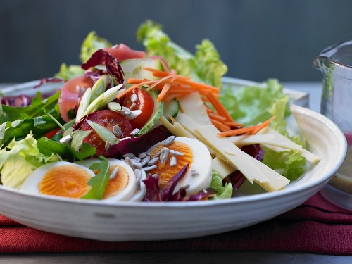 A mixed salad with cheese, ham and egg