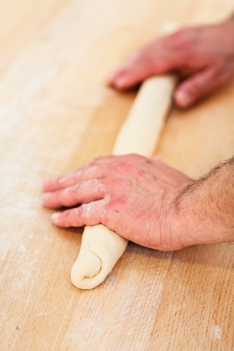 Dough being rolled into a baguette shape