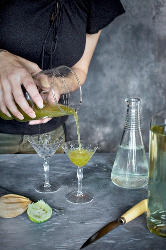 A women is pouring a matcha wine cocktail
