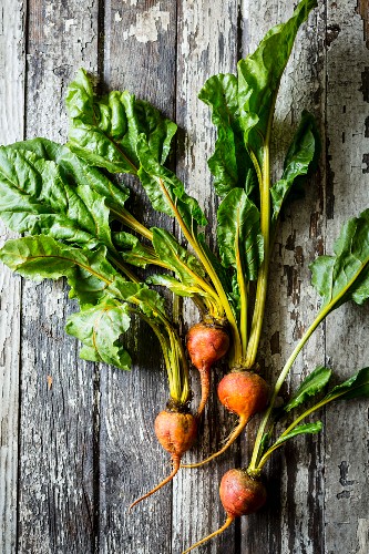 Beets with leaves on a vintage wooden table background
