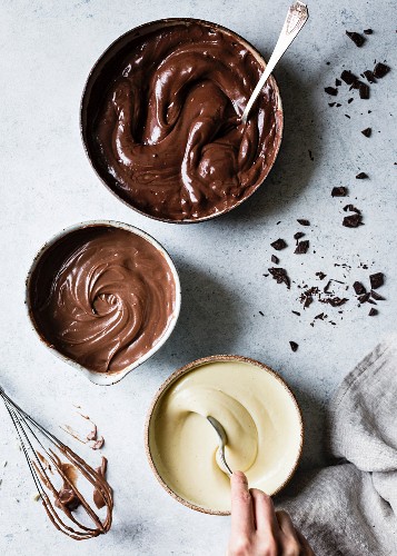 Bitterschokolade, Milchschokolade und weiße Schokolade, geschmolzen in Schälchen
