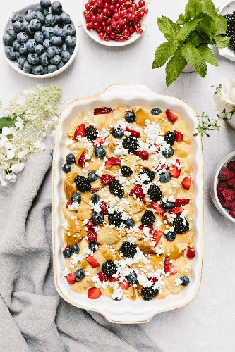 An unbaked goat's cheese and berry bread pudding in an ovenproof dish