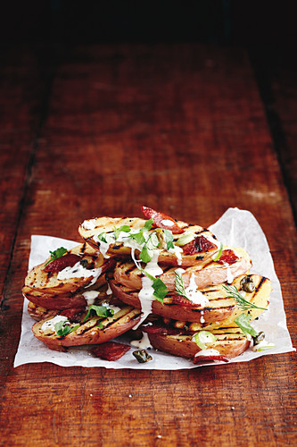 Grilled potatoes with bacon and capers