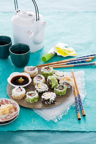 Various inside-out sushi rolls with soy sauce, ginger and wasabi
