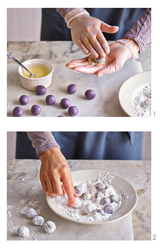 Blueberry truffles being rolled and covered in icing sugar