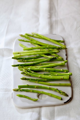 Fresh green asparagus spears on a chopping board