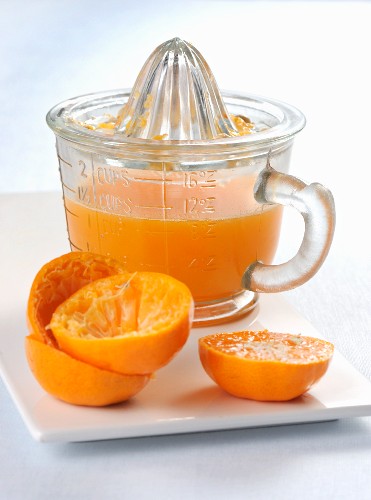 Frisch gepresster Orangensaft in Saftpresse