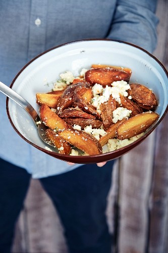 Fried potato wedges with feta cheese and thyme