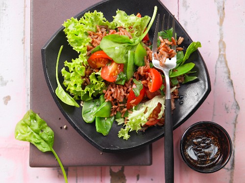 Vegetable salad with red rice, tomato, mangetout and spinach