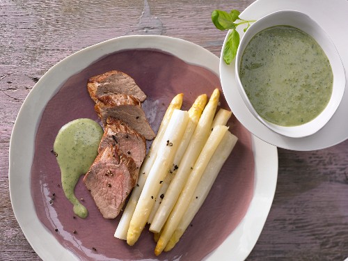 Oven-baked asparagus with pork fillet and basil sauce