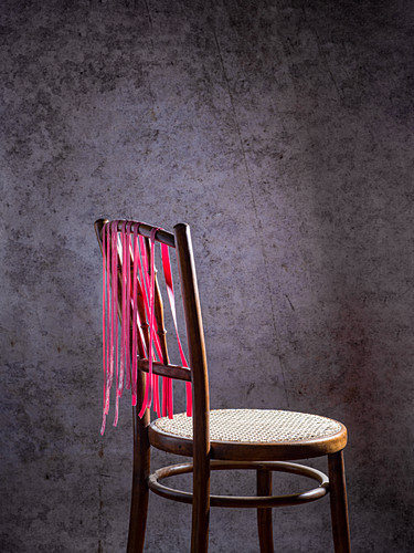 Homemade beetroot pasta drying on a wooden chair
