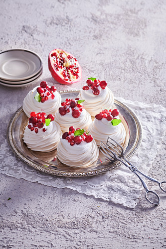 Small meringue Pavlova with whipped cream and pomegranate