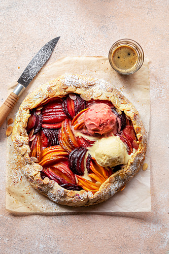 Freshly baked stone fruit galette with two dollops of ice cream on top