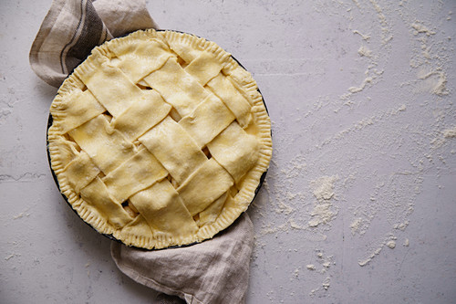 Uncooked apple pie with a wide lattice on top