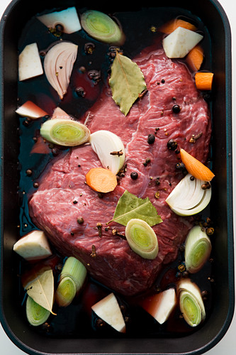 Raw marinated pot roast with vegetables and spices