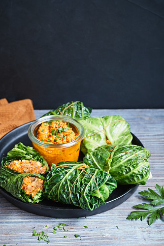 Savoy cabbage roulade filled with vegetables and walnuts and served with pumpkin sauce