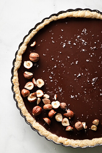 A salted chocolate hazelnut tart on marble