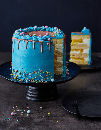 Mango and passion fruit drip cake with blue buttercream