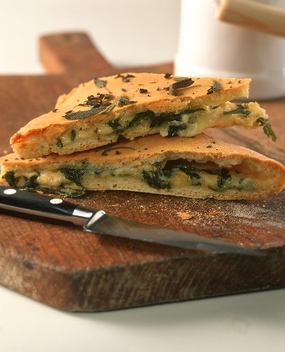 Focaccia with cheese and rocket filling on chopping board
