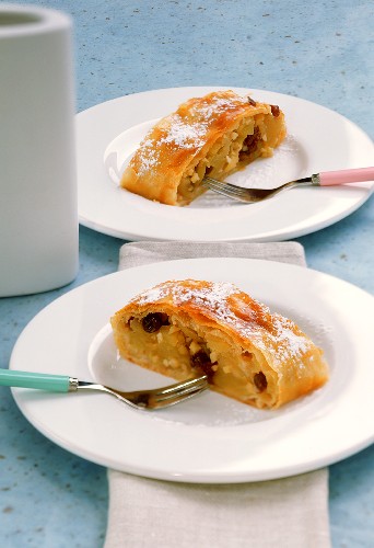 Apfelstrudel mit Puderzucker auf zwei Tellern