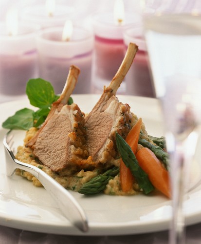 Two slices of rack of lamb with vegetables on chick-pea puree