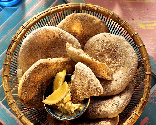 Arabic flat bread in bread basket with spread
