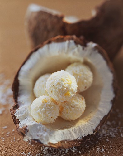 Coconut chocolates with grated coconut in half a coconut