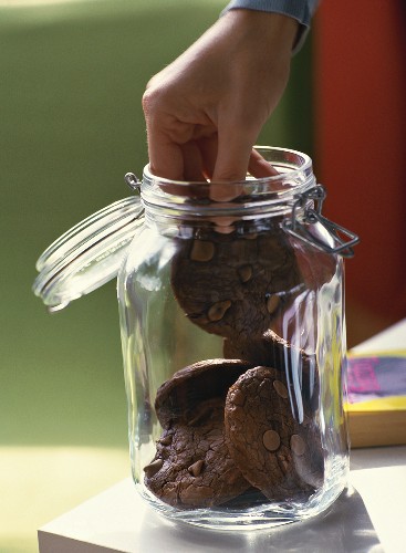 Taking chocolate biscuit out of storage jar