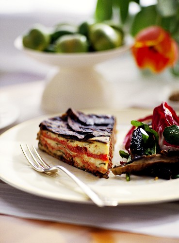 Piece of aubergine and pepper cake with salad