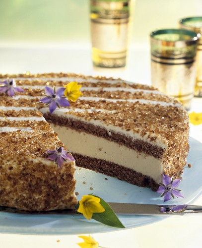 Tea punch cake with edible flowers, a piece taken