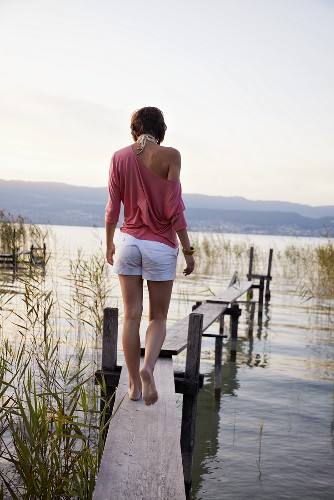 Junge Frau auf dem Steg am See