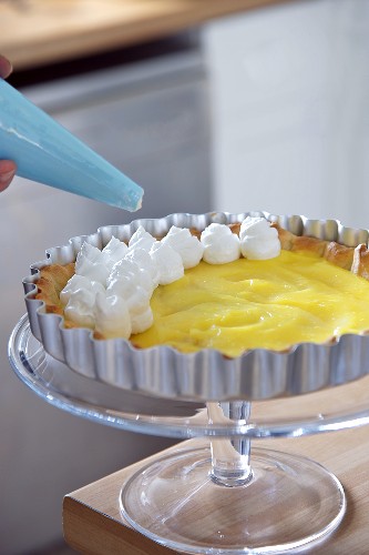 Lemon pie being decorated with meringue