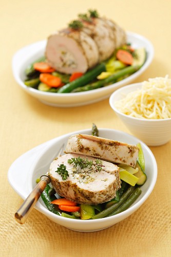 Turkey roulade with herb cheese and pea stuffing on vegetables