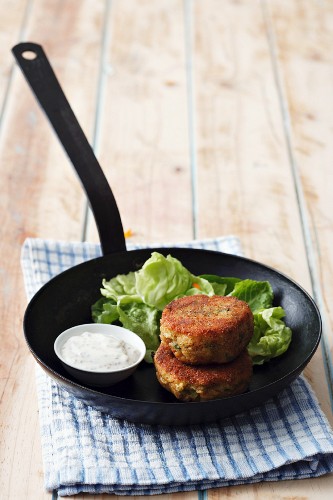 Fischbratlinge mit Dip und Salat in einer Pfanne