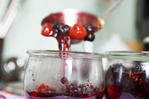 Ladling berry jam into jar