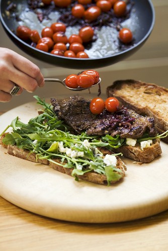 Making a steak and tomato sandwich