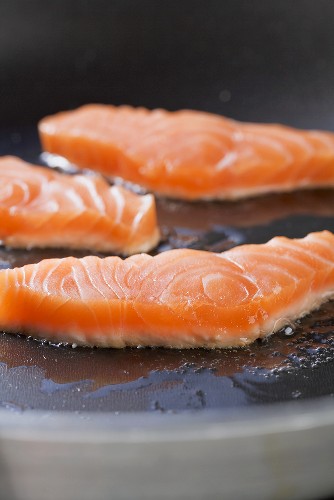 Slices of salmon being fried
