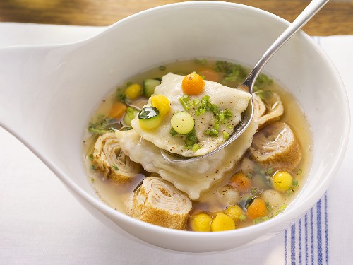 Goose broth with ravioli and pancake rolls