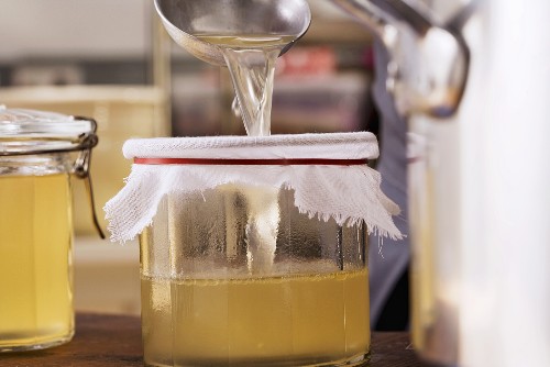 Light stock being poured into a preserving jar