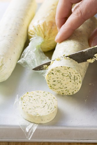 A roll of herb butter being sliced